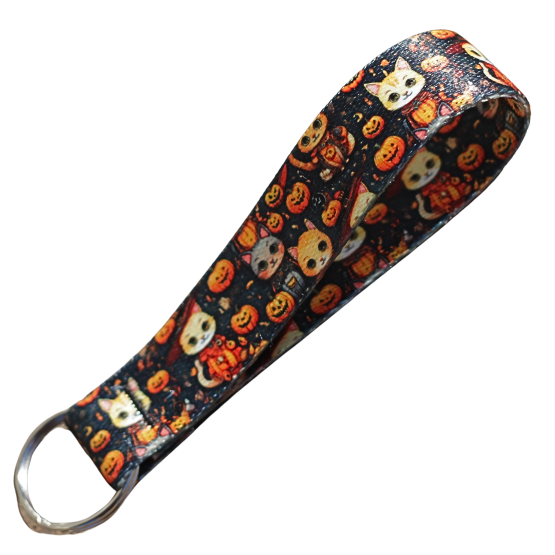 Halloween cat-themed keychain wrist lanyard with pumpkins and spooky designs on black webbing.